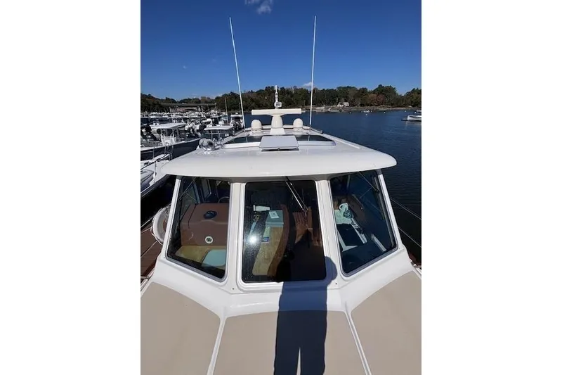 Slide: The Image of 2012 Sabre 42 Salon Express yacht docked at marina under clear blue sky. - 43