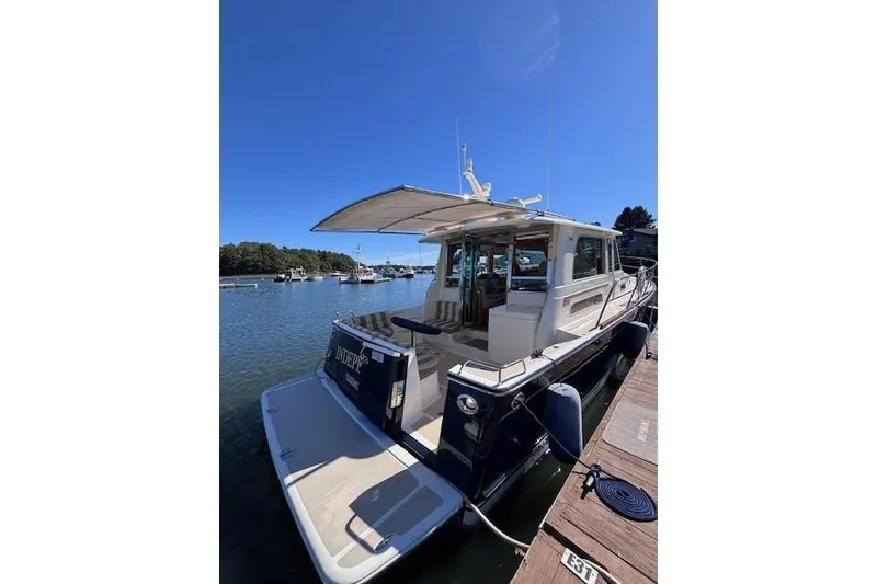Slide: The Image of 2012 Sabre 42 Salon Express yacht docked in a serene marina setting. - 44