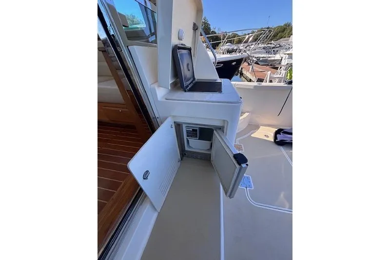 Slide: The Image of 2012 Sabre 42 Salon Express yacht interior with open storage compartment and laptop. - 5