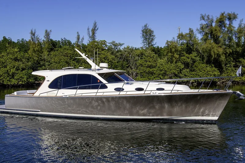 The Image of 2017 Palm Beach PB42 yacht cruising on calm waters with lush greenery background. - 0