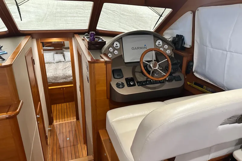Slide: The Image of 2017 Palm Beach PB42 yacht interior with helm, Garmin display, and cozy cabin view. - 18