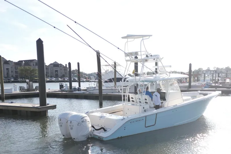 Slide: The Image of 2020 Cobia 350 Center Console boat docked at marina with twin engines. - 11