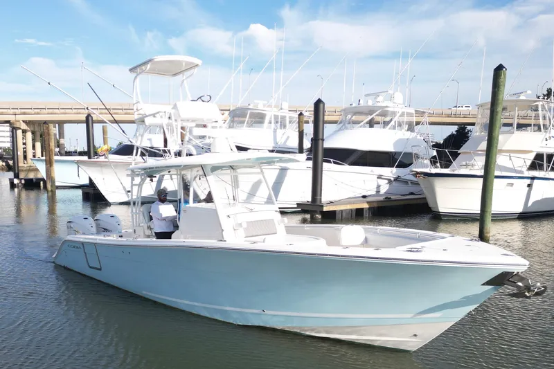 Slide: The Image of 2020 Cobia 350 Center Console boat docked in marina with other yachts. - 13