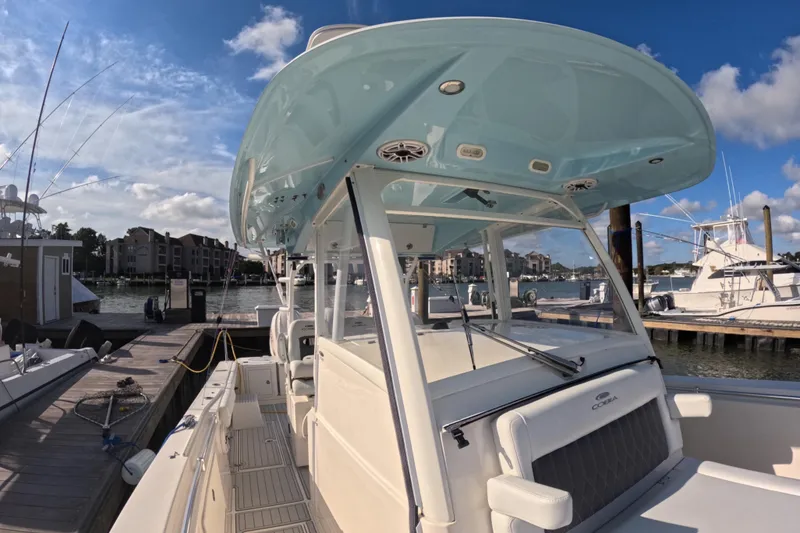 Slide: The Image of 2020 Cobia 350 Center Console boat docked at marina under blue sky. - 5