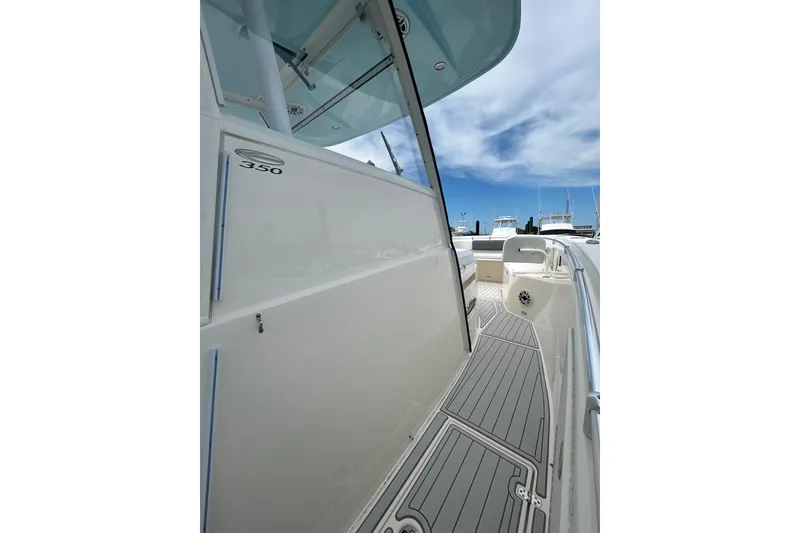 Slide: The Image of 2020 Cobia 350 Center Console boat deck with sleek design and clear blue sky. - 8
