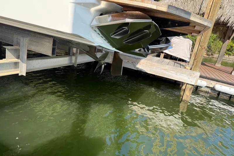 Slide: The Image of 2022 MasterCraft NXT24 boat covered in a dock, surrounded by a scenic lake view. - 11