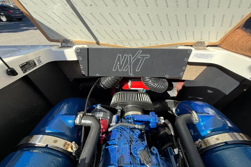 Slide: The Image of 2022 MasterCraft NXT24 engine compartment with visible components and branding. - 23