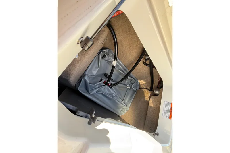Slide: The Image of 2022 MasterCraft NXT24 storage compartment with ballast bag and hoses. - 24