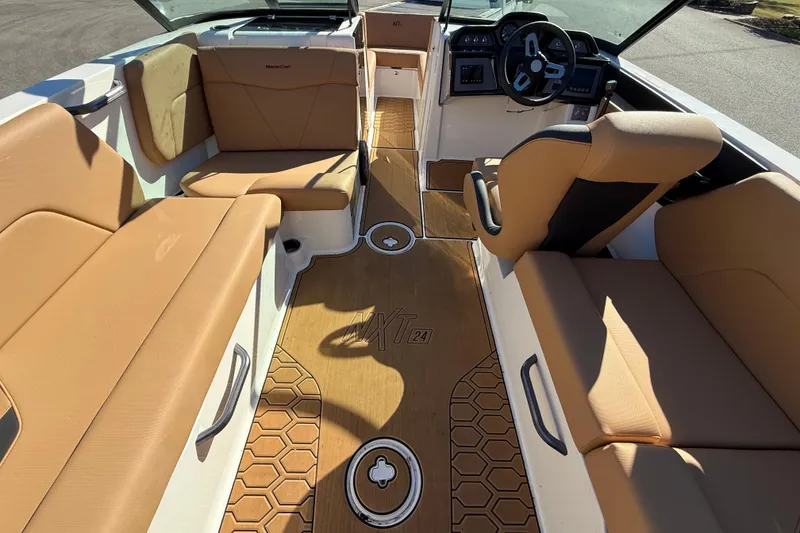 Slide: The Image of 2022 MasterCraft NXT24 boat interior with tan seating and modern dashboard. - 26