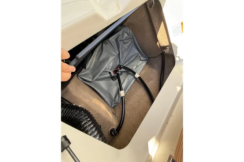 Slide: The Image of 2022 MasterCraft NXT24 storage compartment with ballast bag and hoses. - 28