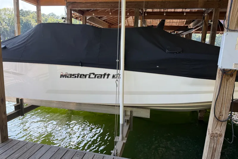 Slide: The Image of 2022 MasterCraft NXT24 boat covered in storage, side view. - 3