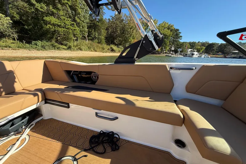 Slide: The Image of 2022 MasterCraft NXT24 boat interior with tan seating and scenic lake view. - 33