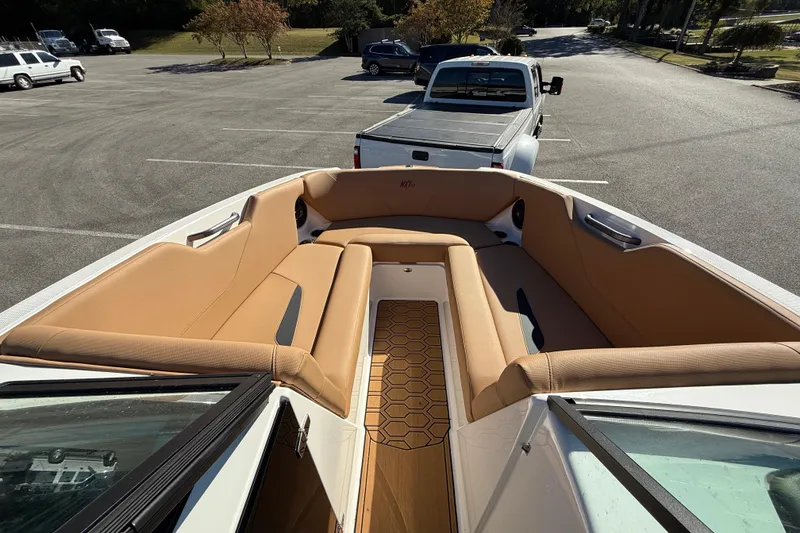 Slide: The Image of 2022 MasterCraft NXT24 boat interior with tan seating in a parking lot. - 37