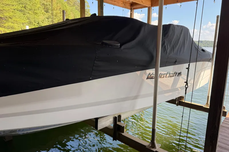 Slide: The Image of 2022 MasterCraft NXT24 boat logo on white hull, partially covered. - 8