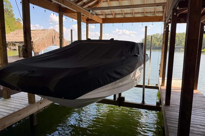 Slide: The Image of 2022 MasterCraft NXT24 boat covered and docked on a lift by the water. - 9
