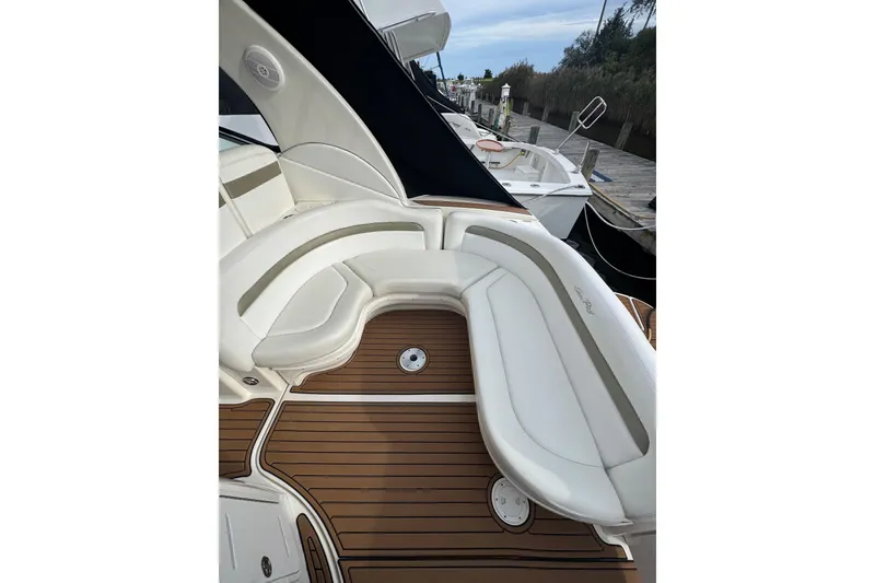 Slide: The Image of 2007 Sea Ray 320 Sundancer boat with white seating and teak flooring at a dock. - 11