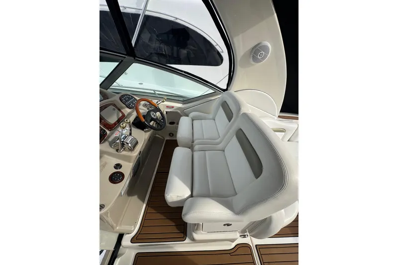 Slide: The Image of 2007 Sea Ray 320 Sundancer cockpit with white seating and wooden accents. - 14