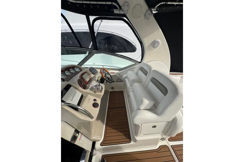 Slide: The Image of 2007 Sea Ray 320 Sundancer cockpit with white seating and Garmin navigation system. - 15