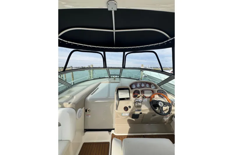 Slide: The Image of 2007 Sea Ray 320 Sundancer helm with Garmin navigation, overlooking calm waters. - 16