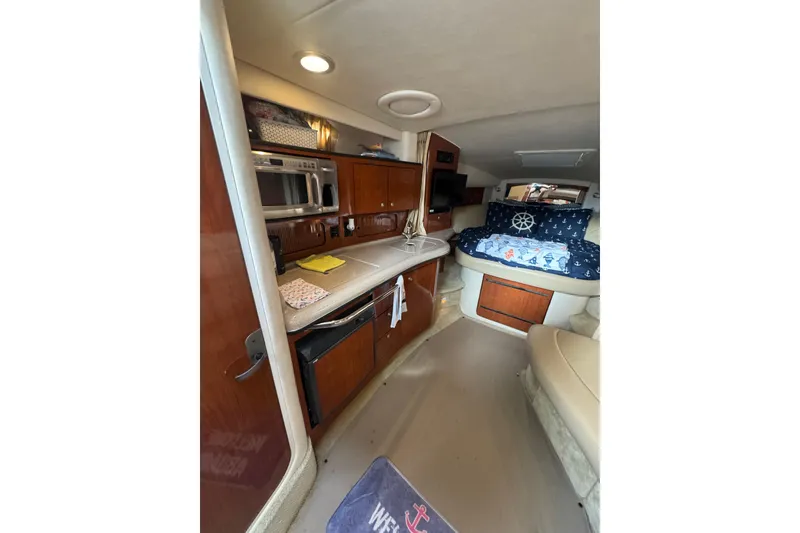 Slide: The Image of 2007 Sea Ray 320 Sundancer interior with kitchenette and cozy sleeping area. - 22
