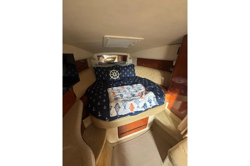 Slide: The Image of 2007 Sea Ray 320 Sundancer cabin with nautical-themed bedding and cozy interior. - 25