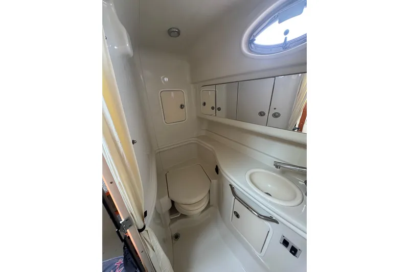 Slide: The Image of Compact bathroom in 2007 Sea Ray 320 Sundancer yacht with sink, toilet, and storage cabinets. - 33