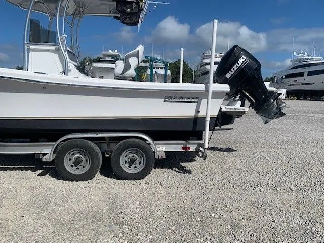 Slide: The Image of A 2021 Privateer 242 WAHOO on a trailer, with Suzuki outboard motor, on a gravel lot. - 27