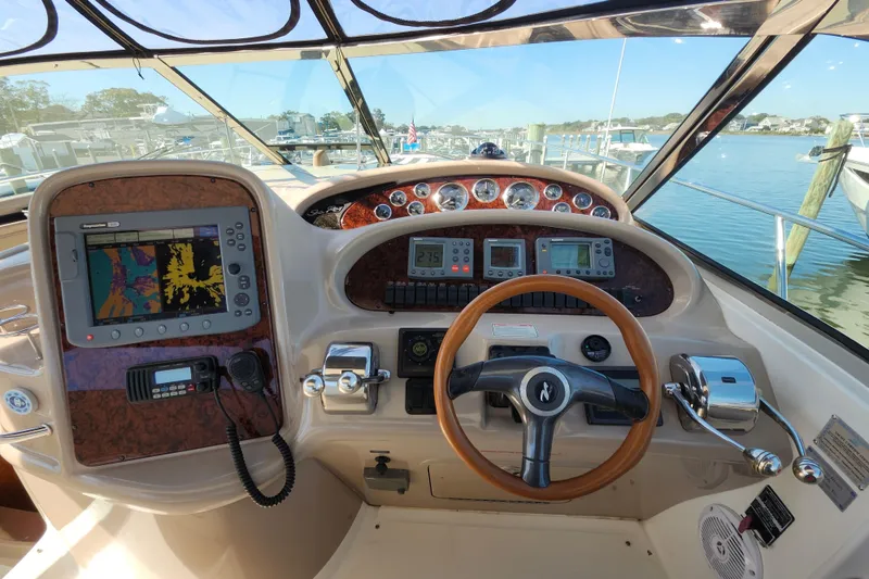 Slide: The Image of Helm of 2002 Sea Ray 410 Sundancer with navigation equipment and steering wheel. - 16