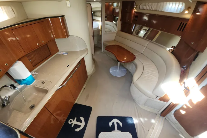 Slide: The Image of Interior of 2002 Sea Ray 410 Sundancer yacht with kitchen and seating area. - 28