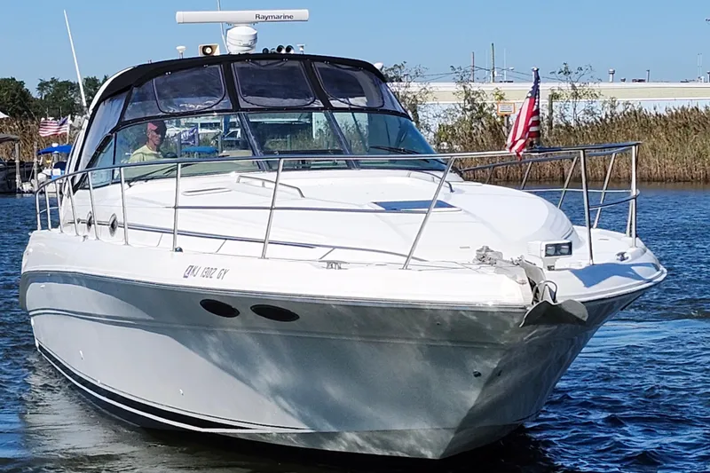 Slide: The Image of 2002 Sea Ray 410 Sundancer yacht cruising on a sunny day with American flag. - 3