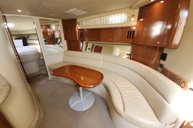 Slide: The Image of Luxurious interior of 2002 Sea Ray 410 Sundancer yacht with curved seating and wooden table. - 30