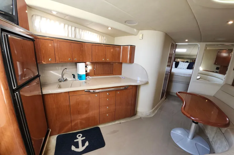 Slide: The Image of Interior of 2002 Sea Ray 410 Sundancer yacht with kitchen and seating area. - 31