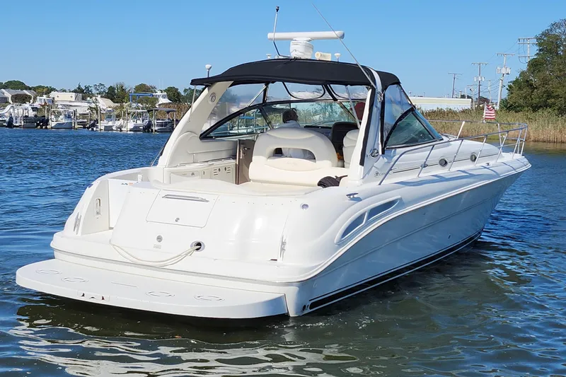 Slide: The Image of 2002 Sea Ray 410 Sundancer yacht on calm water, featuring sleek white design. - 4