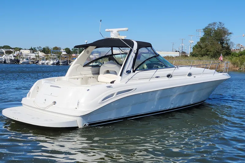 Slide: The Image of 2002 Sea Ray 410 Sundancer yacht on calm water, featuring sleek design and spacious deck. - 5