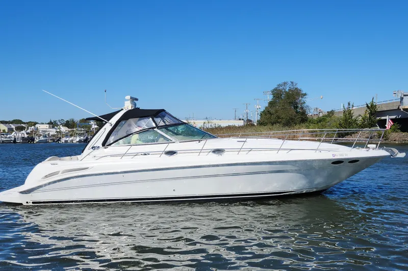 Slide: The Image of 2002 Sea Ray 410 Sundancer yacht on calm water under clear blue sky. - 6