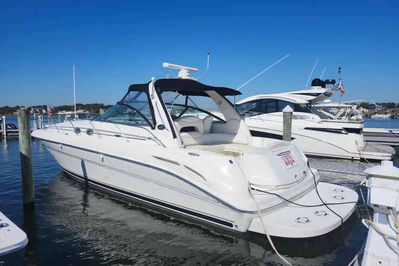 Slide: The Image of 2002 Sea Ray 410 Sundancer yacht docked at marina under clear blue sky. - 9