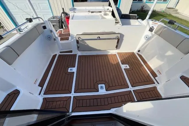 Slide: The Image of 2020 Cutwater C-24 Coupe boat deck with wood finish and seating area. - 10