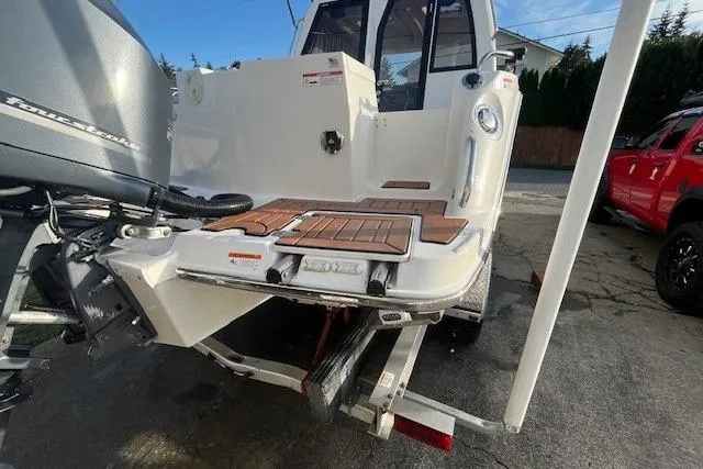 Slide: The Image of 2020 Cutwater C-24 Coupe boat rear view with outboard motor and teak deck. - 15