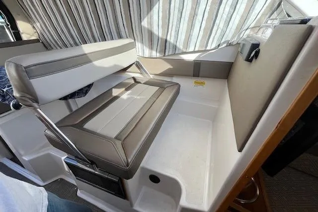 Slide: The Image of 2020 Cutwater C-24 Coupe interior seating with striped curtains and cushioned bench. - 22