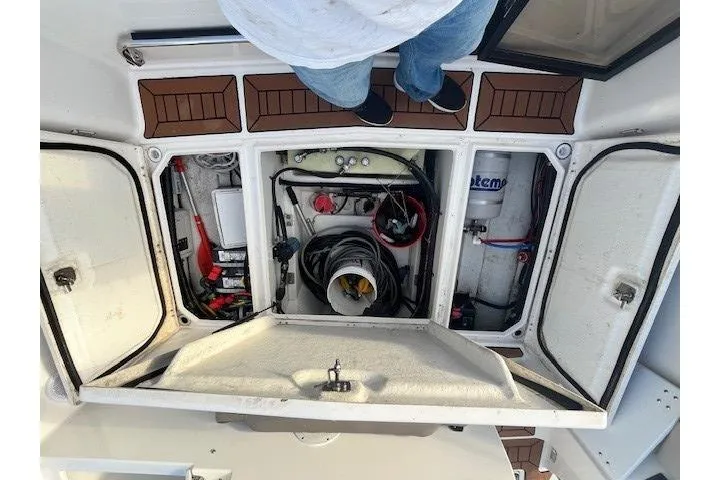 Slide: The Image of Engine compartment of a 2020 Cutwater C-24 Coupe boat, showing mechanical components and storage. - 27