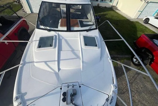 Slide: The Image of 2020 Cutwater C-24 Coupe boat, top view, parked near red and white vehicles. - 6