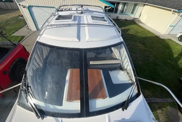Slide: The Image of 2020 Cutwater C-24 Coupe boat with sunroof and windshield, parked in a residential driveway. - 7