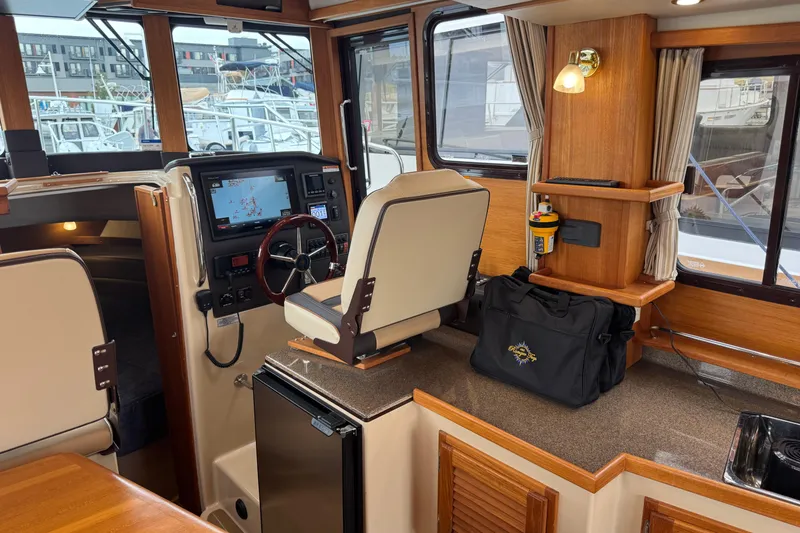 Slide: The Image of 2019 Ranger Tugs R-31 S interior with helm, navigation system, and wooden cabinetry. - 10