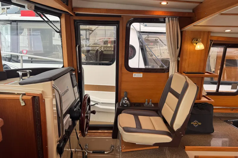 Slide: The Image of 2019 Ranger Tugs R-31 S interior with helm, seating, and wood accents. - 11