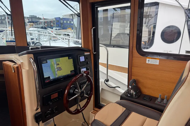 Slide: The Image of 2019 Ranger Tugs R-31 S helm with navigation display and steering wheel. - 12