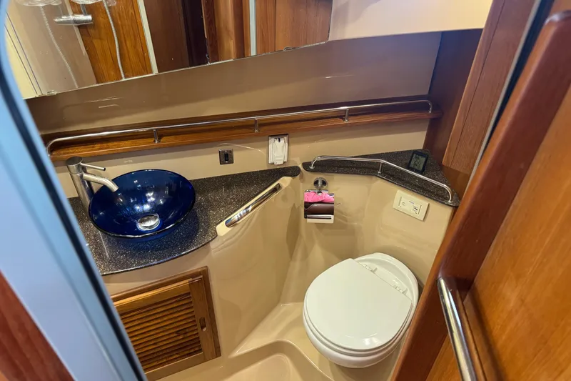 Slide: The Image of 2019 Ranger Tugs R-31 S bathroom with modern sink and toilet, wood accents. - 18