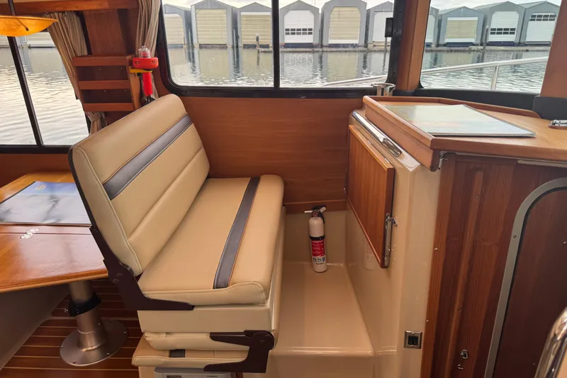 Slide: The Image of Interior of 2019 Ranger Tugs R-31 S with beige seating and wooden cabinetry. - 19