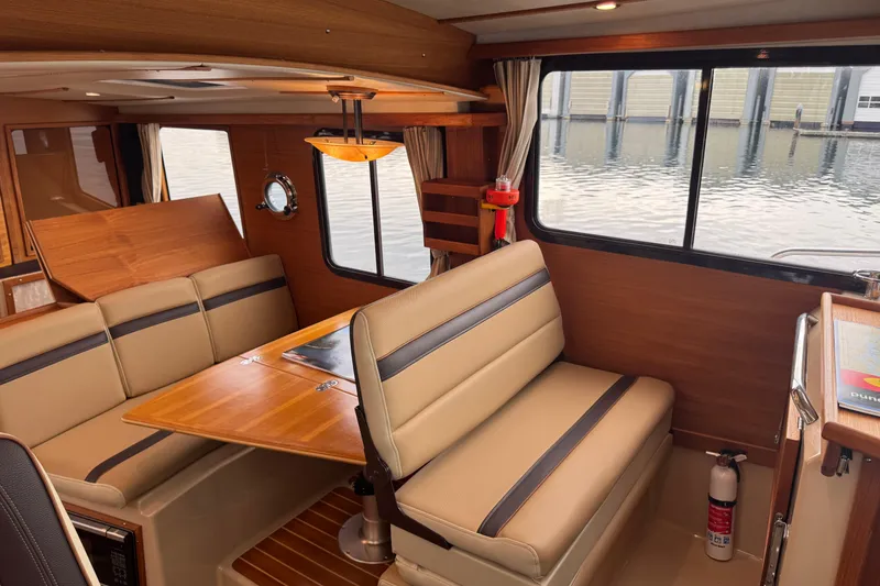 Slide: The Image of Interior of 2019 Ranger Tugs R-31 S with beige seating and wooden table. - 20