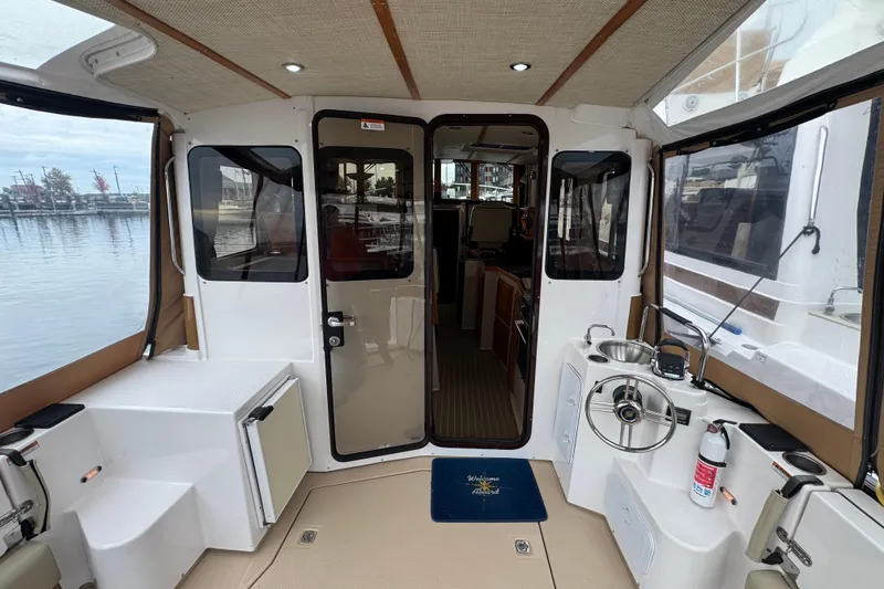 Slide: The Image of 2019 Ranger Tugs R-31 S boat interior with helm, sink, and seating area. - 26