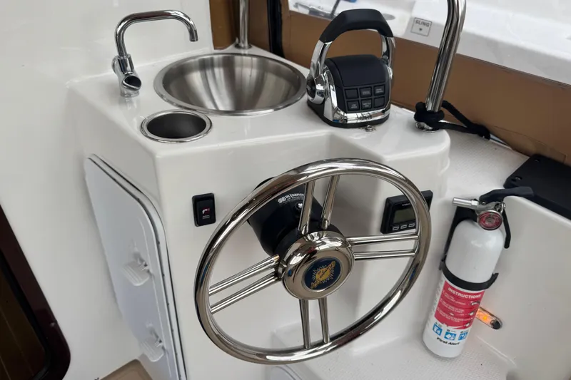 Slide: The Image of 2019 Ranger Tugs R-31 S helm with steering wheel, sink, and fire extinguisher. - 27